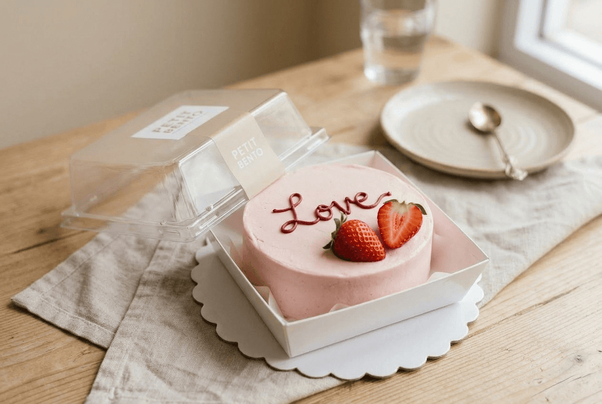 Bento cake chocolat-fraise dans sa boîte bento avec message personnalisé en crème rose